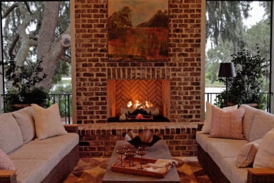 outdoor fireplace with white couches surrounding it